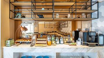 Una colazione a buffet con diversi cibi, una macchina da caffè e un distributore d'acqua.