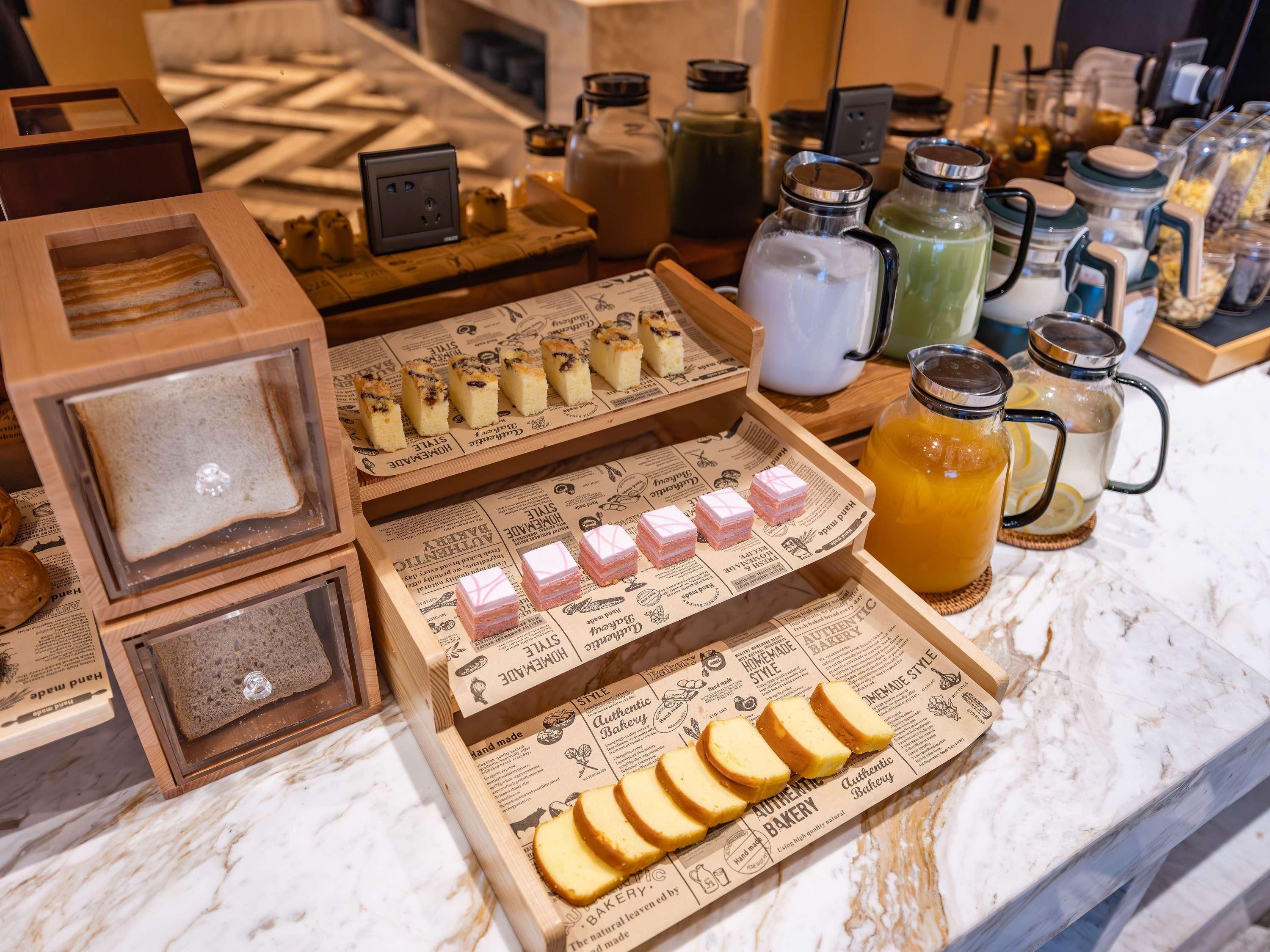 A bakery display with various baked goods and beverages.