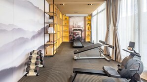 A modern gym with exercise equipment, a treadmill, and a stationary bike. - Mercure Shanghai Pudong Zhangjiang Park (Zhoushan)