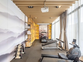 Un gimnasio moderno con equipo de ejercicio, una cinta de correr y una bicicleta estática.