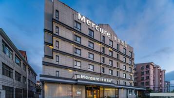 A multi-story hotel with a modern design, featuring a prominent 'Mercure' sign on the facade.