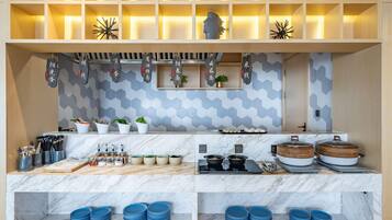 A modern kitchen with marble countertops, a hexagonal tile backsplash, and wooden shelves.