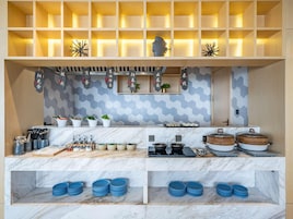 Una cocina moderna con encimeras de mármol, un salpicadero de azulejos hexagonales y estantes de madera.