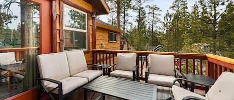 A wooden deck with a sofa, chairs, and a table.