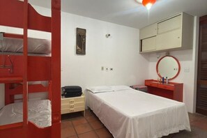 A room with bunk beds, a single bed, a dresser, a mirror, and a wall-mounted cabinet. - Enseada Beach, Guarujá - For 10 people (Guarujá)