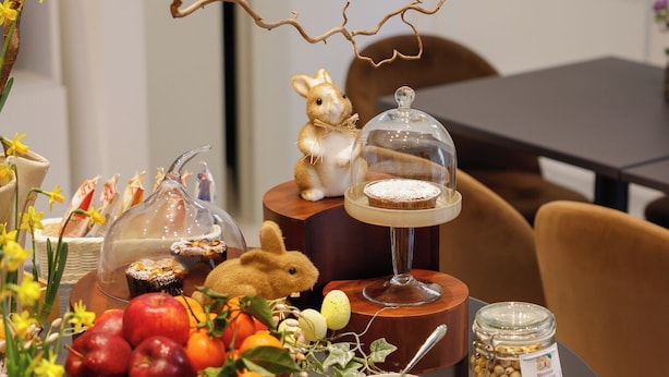 A dining table with a glass top, various food items, a small figurine, and decorative branches. - Dama Luxury Apartment (Pompei)