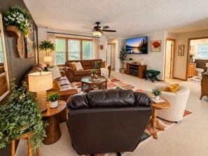 Ein Wohnzimmer mit einer Couch, einem Couchtisch und einem Fernseher.