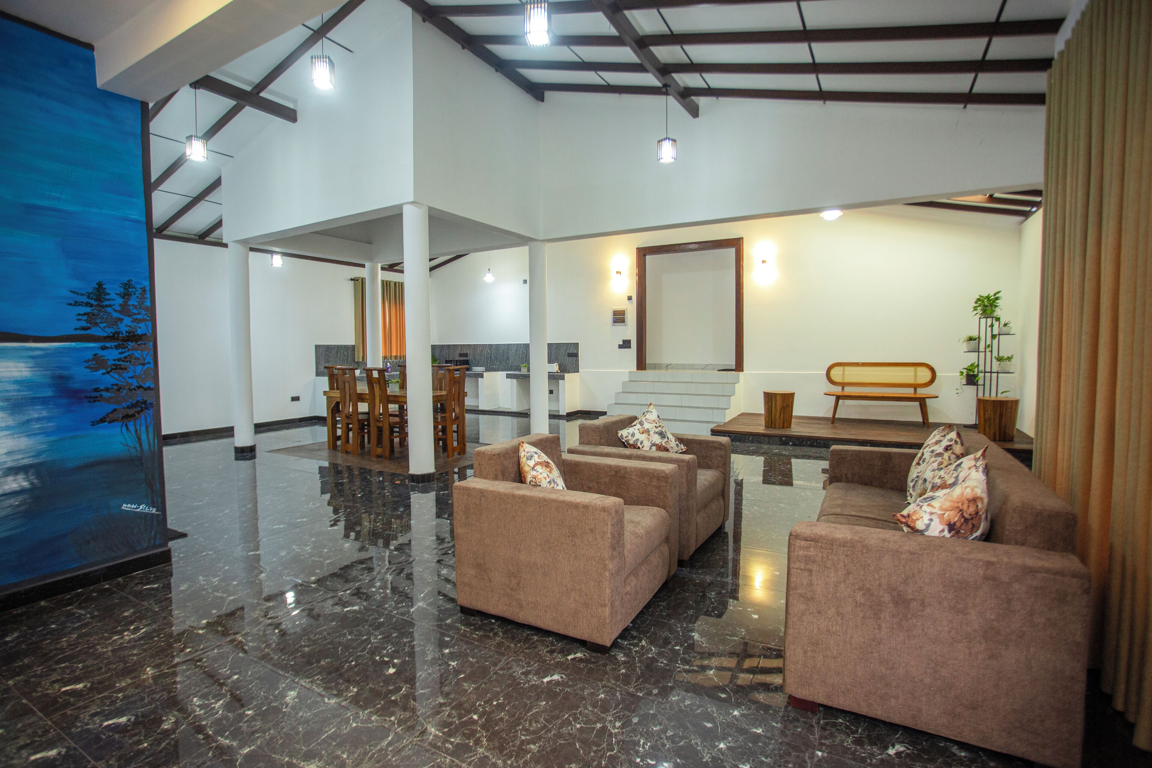 A spacious lobby with a marble floor, a large painting, and a seating area with sofas and a bench.