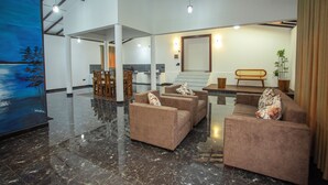 Eine großzügige Lobby mit Marmorboden, einem großen Gemälde und einer Sitzecke mit Sofas und einer Bank.