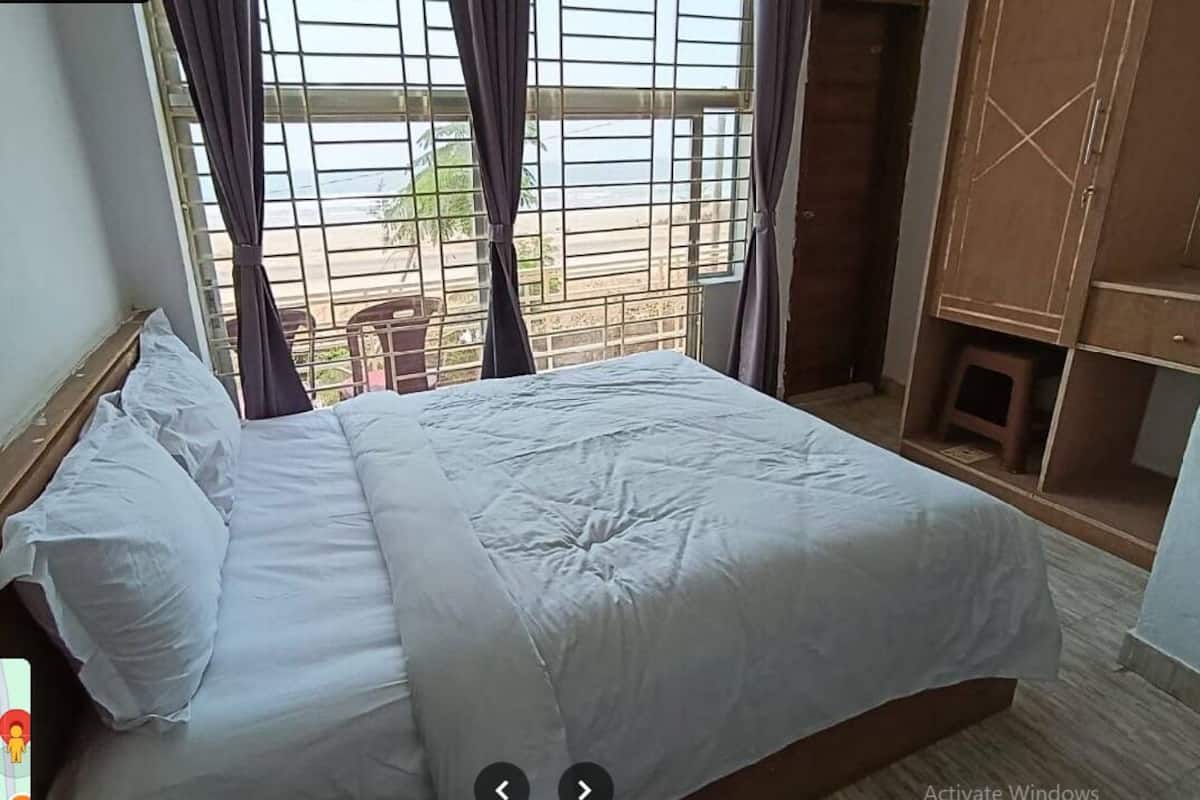 Ein Schlafzimmer mit einem großen Bett, einem Kleiderschrank und einem Fenster mit Vorhängen.