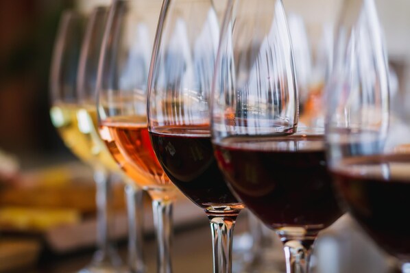 A row of wine glasses with varying levels of liquid.