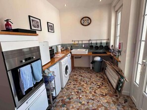 A compact kitchen with a washing machine, a stove, and a sink. - Pet Friendly & Accessible 3-Bed Gite, Sleeps 6 (Sourdeval)