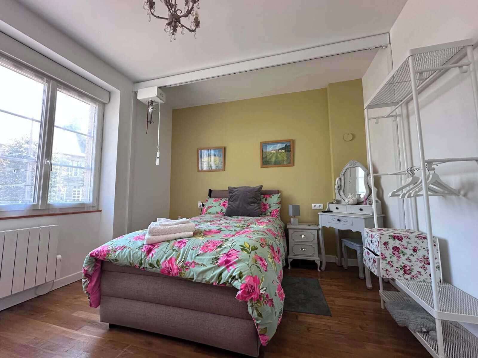 A bedroom with a bed, dresser, and a window.
