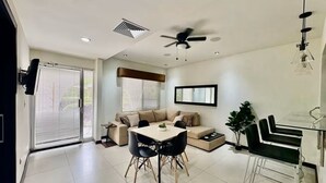 Ein stilvolles Wohnzimmer mit Esstisch, Sofa und einem Glastisch.
