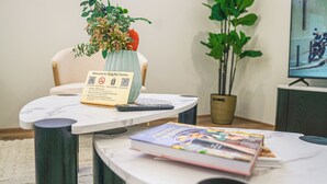 Een receptiebalie met een welkomstbord, een bloevas, een boek en een televisie waarop een motorfiets te zien is.
