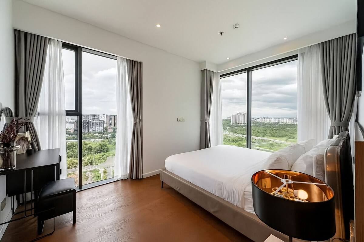 Ein modernes Hotelzimmer mit einem großen Bett, einem Schreibtisch und Blick auf die Stadt.