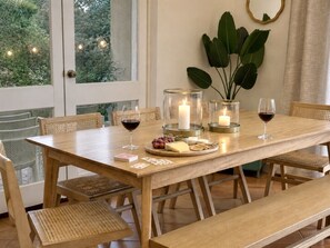 Ein Holztisch mit Kerzen, Weingläsern und einer Käseplatte.