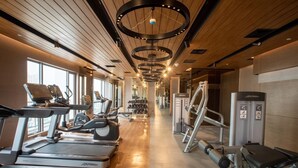 A gym with treadmills, elliptical machines, and weight equipment. - The Hotel Residences at Aqua - Premier Suite  (Mandaluyong City)