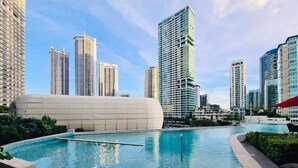 A modern building complex with a central pool area, surrounded by high-rise residential buildings. - The Hotel Residences at Aqua - Premier Suite  (Mandaluyong City)