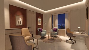 A modern living room with a sofa, armchairs, a coffee table, and a desk with a laptop. - Vivanta Gurugram, Sector 95A (Gurugram)