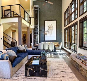 A spacious living room with a sectional sofa, a coffee table, and a dining area with chairs.
