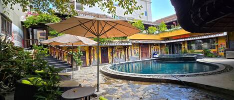 A courtyard with a swimming pool, outdoor seating, and a building labeled "Brew House."