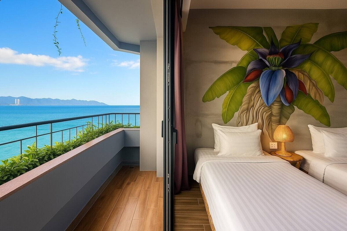 Un balcon avec vue sur la mer et les montagnes, un lit avec du linge de lit blanc et une grande plante accrochée au mur.