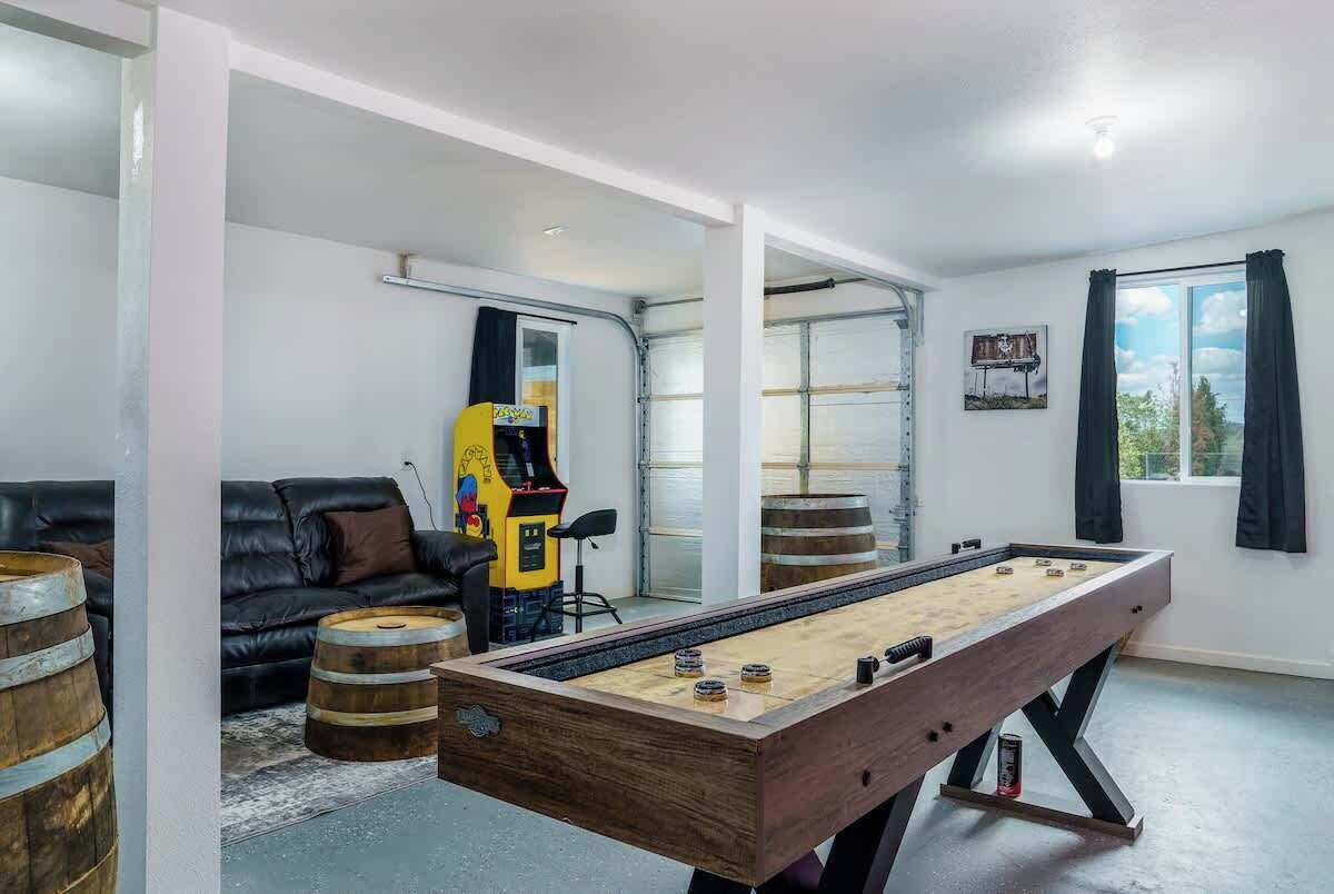 Een kamer met een tafelvoetbaltafel, een bank en een jukebox.