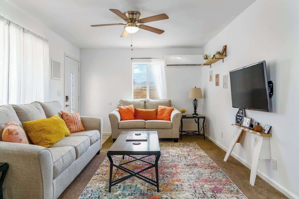 Uma sala de estar com sofá, mesa de centro e televisão.