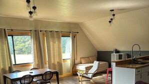 A spacious loft with a dining area, seating, and a kitchenette.
