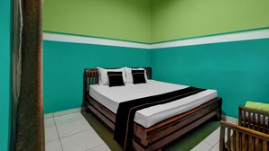 A room with a bed, green walls, and a white ceiling. - OYO 3738 Pemda 22 Mansion (Bogor)