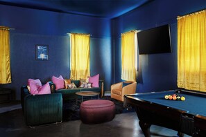 A room with a pool table, a sofa, a chair, and a television mounted on the wall. - 3 Acre Estate Hot Tub Karaoke Pickleball Glam Room (Nashville)