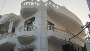 Ein mehrstöckiges Gebäude im klassischen Stil, mit Balkonen und aufwendig gestalteten Geländern sowie einer symmetrischen Fassade.