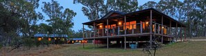A large wooden cabin with a balcony, surrounded by trees. - Tiny Away Escape at Granite Belt (Stanthorpe)