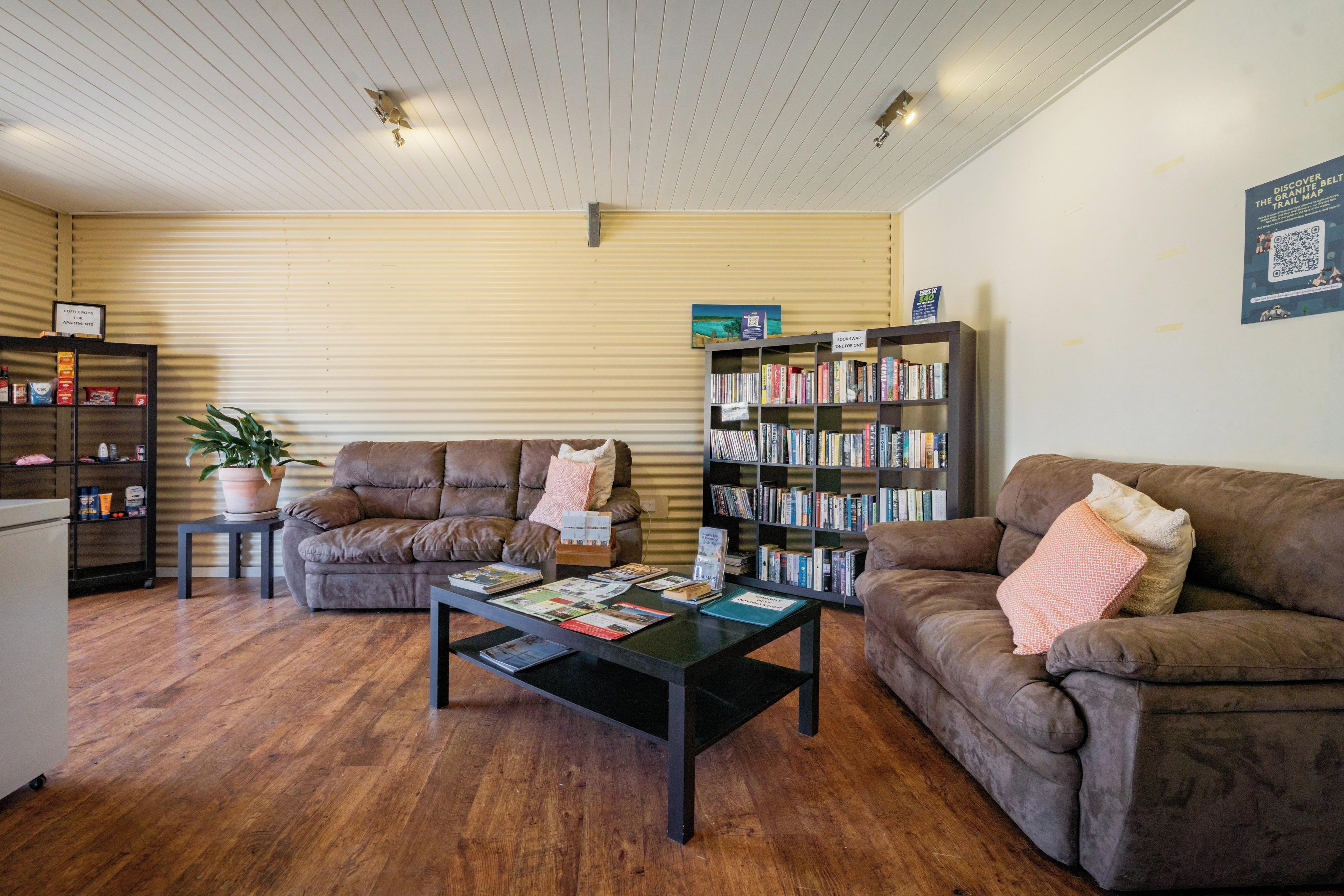 A cozy living area with two sofas, a coffee table, and a bookshelf.