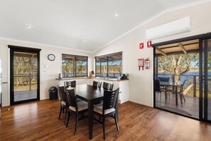 Una cocina moderna con comedor, ventanas amplias y vistas al exterior.