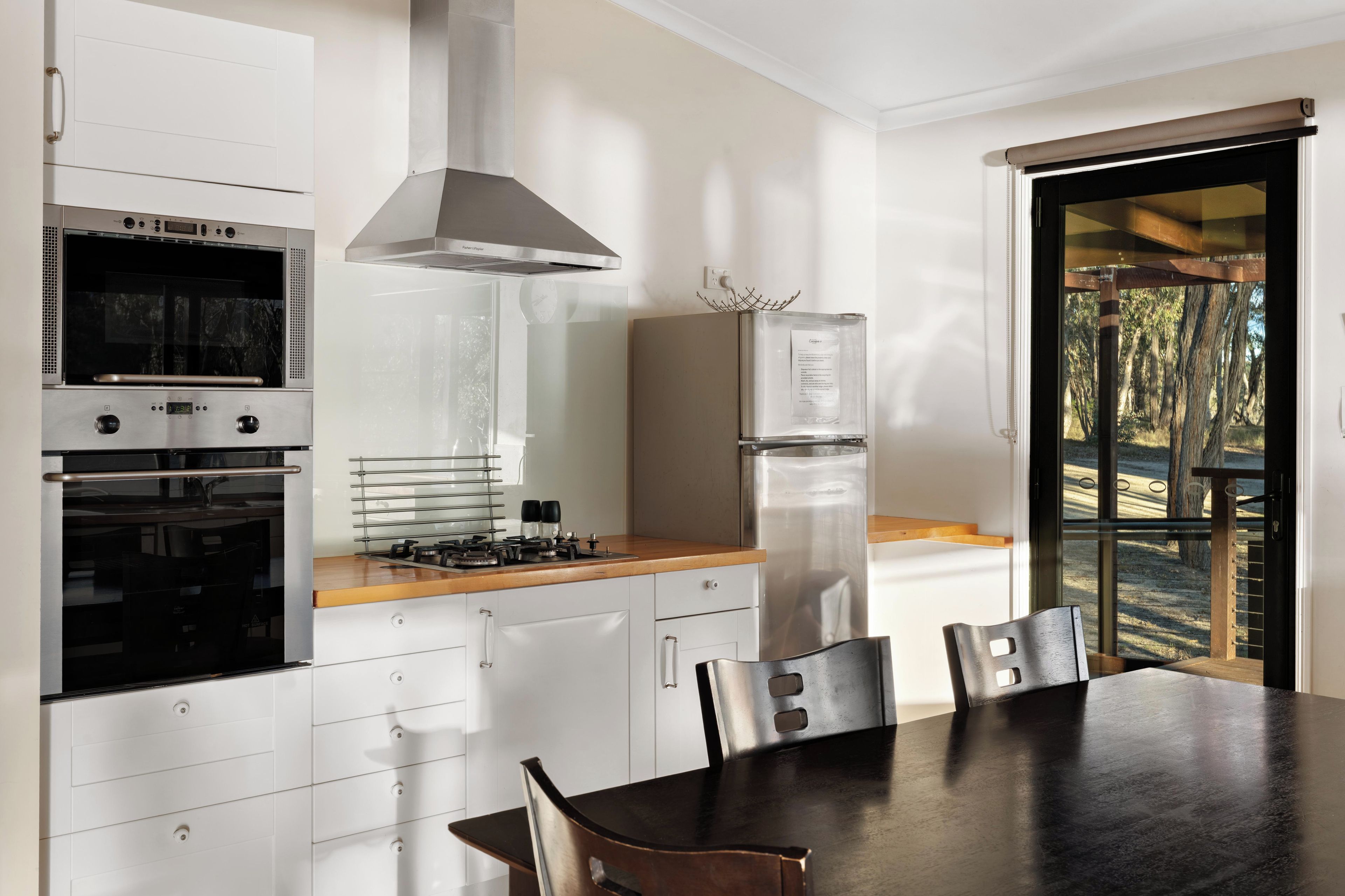 A modern kitchen with a built-in oven, a stainless steel range, and a refrigerator.
