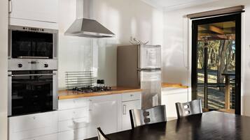 A modern kitchen with a built-in oven, a stainless steel range, and a refrigerator.