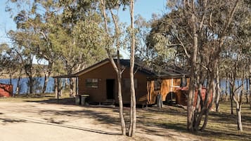 A single-story cabin with a sloped roof, a front porch, and a visible door.