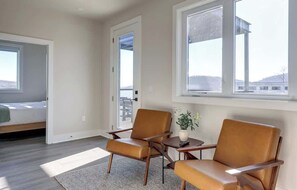 A room with a bed, two chairs, a small table with a plant, and large windows. - Pet-Friendly in Belmont near UVA & Downtown - #311 (Charlottesville)