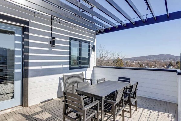 A covered patio with a table and chairs, a pergola, and a view of the landscape. - Pet-Friendly in Belmont near UVA & Downtown - #311 (Charlottesville)