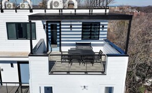 A modern two-story building with a flat roof, large windows, and a balcony with a bench. - Pet-Friendly in Belmont near UVA & Downtown - #311 (Charlottesville)