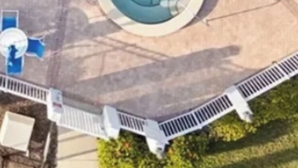 An aerial view of a swimming pool with a circular hot tub area, surrounded by a paved deck with lounge chairs. - San marco villas 2-bedroom newly updated condo in lovely Marco Island  (Marco Island)