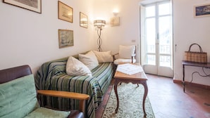 Een gezellige kamer met een gestreept sofa, een houten tafel en een rieten mand.