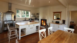 Un'ampia cucina con una grande isola, pavimento in legno e camino.