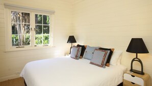 Una camera da letto con un letto grande, due comodini e una finestra con persiane.