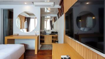 Una habitación de hotel moderna con cama, escritorio, baño y un ventanal grande.