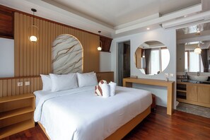Ein modernes Hotelzimmer mit einem großen Bett, Holzvertäfelung, einer Marmorwand, einem runden Spiegel und einem Holzanrichte mit Waschbecken.