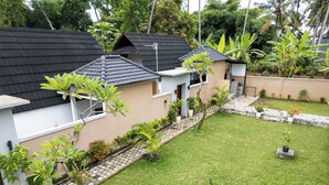 A residential area with houses featuring sloped roofs and a well-maintained lawn. - Merta Luwih villa (Tabanan)