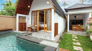 A modern villa with a swimming pool, a covered outdoor seating area, and a kitchen visible through a glass door. - Merta Luwih villa (Tabanan)